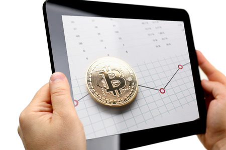 Male arms hold tablet pc with btc sign coinsの写真素材