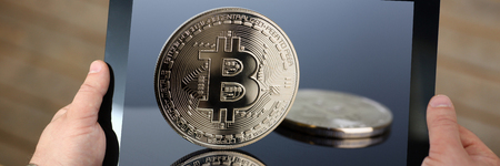 Hipster arms hold tablet pc with btc sign coinsの写真素材