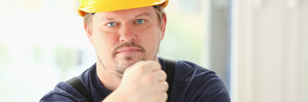 Smiling funny worker in yellow helmetの写真素材