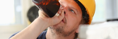 Arm of drunken worker in yellow helmetの写真素材