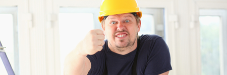 Smiling funny worker in yellow helmetの写真素材