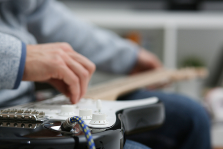 Male hands at home playing guitarの写真素材