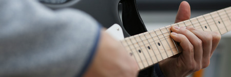 Male hands tuning guitarの写真素材