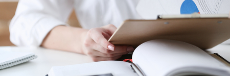 Female hands hold clipboard pad with financialの写真素材