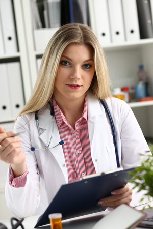 Beautiful smiling female doctor hold clipboardの写真素材
