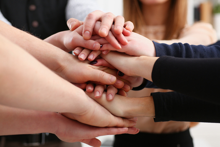 Group of people in suits crossed hands in pile for winの写真素材