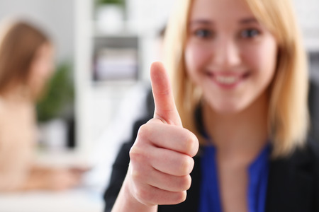 Beautiful smiling woman showing OKの写真素材