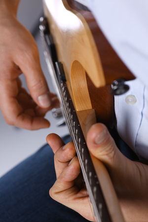 Male arms playing classic shape electric guitarの写真素材