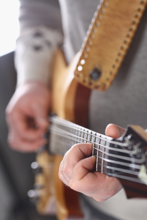 Male arms playing classic shape electric guitarの写真素材