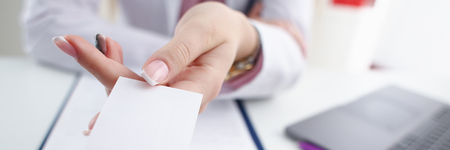 Female physician hand give white blankの写真素材