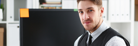 Handsome smiling man in suit and tie stand in office Handsome smiling man in suit and tie stand in office