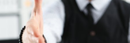 Man in suit and tie give hand as hello in officeの写真素材