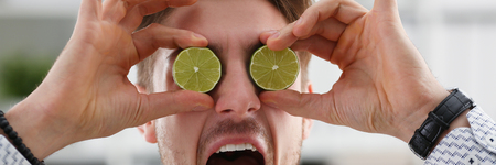 Male hands hold a cut fruit at eye levelの写真素材