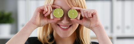 Female hands hold a cut fruit at eye levelの写真素材