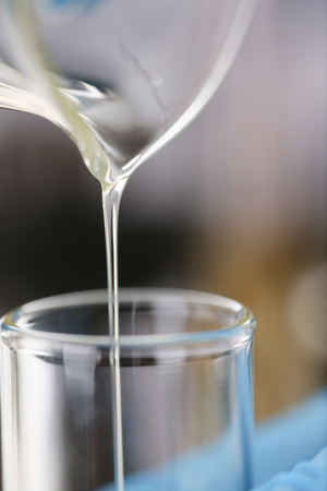 Male hands in protective gloves hold test tubeの写真素材