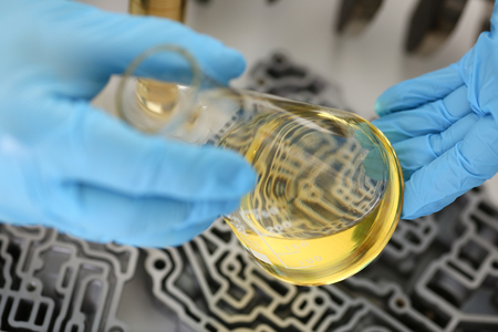 Male hands in protective gloves hold test tubeの写真素材