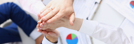 Group of people in suits crossed hands