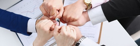 Group of people in suits crossed hands