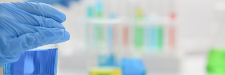 Female chemist holds test tube of glassの写真素材