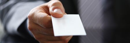 Male arm in suit give blank calling cardの写真素材