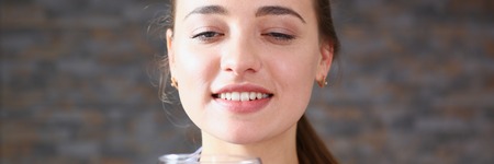 Beautiful woman hold in arms glass of red wineの写真素材