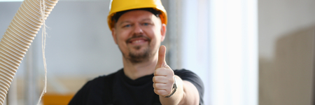 Smiling worker in yellow helmet show confirm signの写真素材