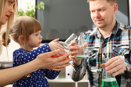 Man and little girl play with colourful liquidsの写真素材