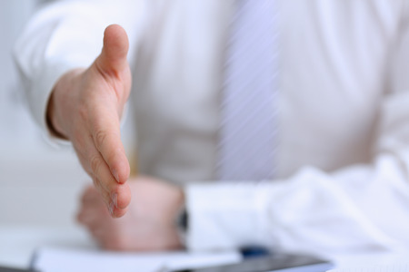 Man in suit and tie give hand as helloの写真素材