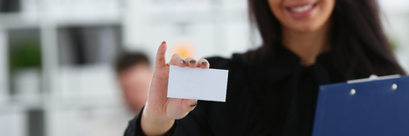 Female arm give blank calling card to visitorの写真素材