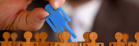 Man arm in suit take little plastic toy figureの写真素材