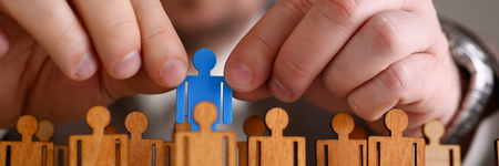 Man arm in suit take little plastic toy figureの写真素材