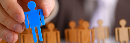 Man arm in suit take little plastic toy figureの写真素材