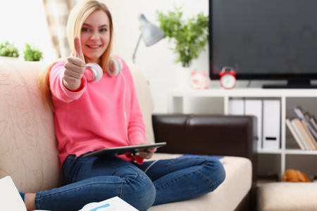 young pretty blond woman hold tablet in arms show big finger superの写真素材