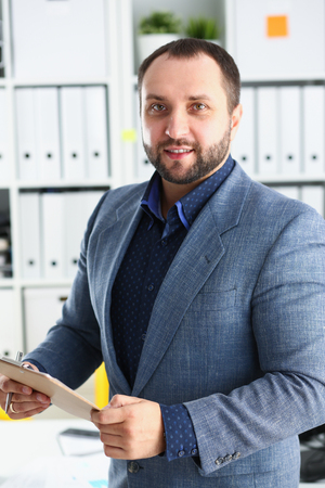 portrait of young handsome promising businessman in officeの写真素材