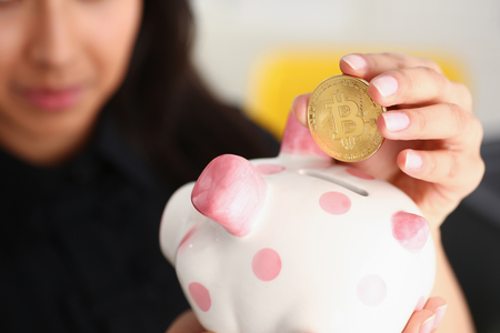 woman hold piggybank in arms put money into moneyboxの写真素材