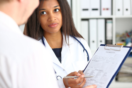 Female doctor hand holding a silver pen and showing the resultの写真素材