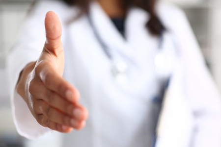 A doctor extending her hand greeting the patientの写真素材