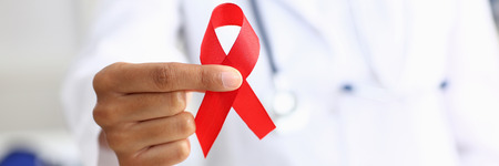 Black woman doctor holding a red ribbonの写真素材