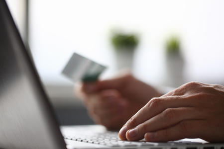 Male arms hold credit card press buttons makingの写真素材