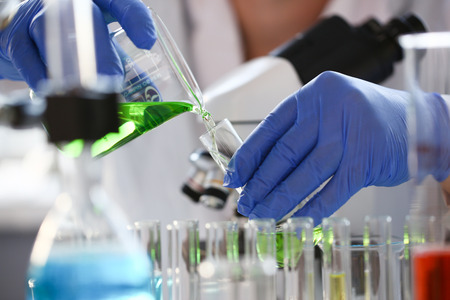 A male chemist holds test tube of glass in his hand