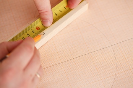 Arms of worker measuring wooden bar closeupの写真素材