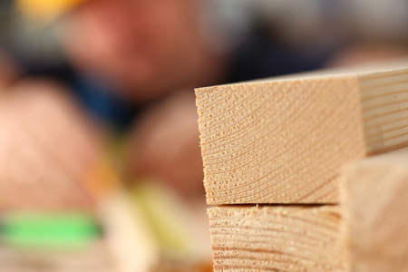Arms of worker measuring wooden bar closeupの写真素材