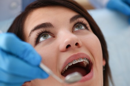 A woman at the reception of a male dentist examiningの写真素材