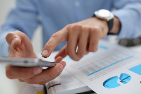 A businessman holds a new smartphone in his hand