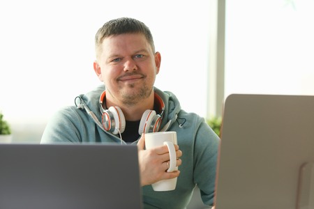 Handsome smiling male student using online