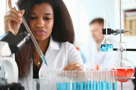 A male chemist holds test tube of glass
