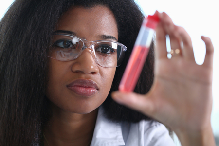 A male chemist holds test tube of glassの写真素材