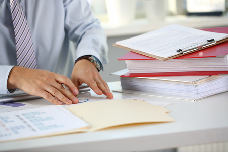Male hands hold documents with financialの写真素材