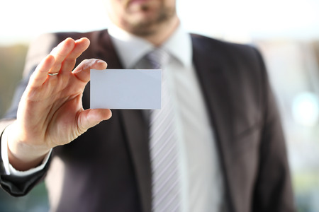 Male arm in suit give blank calling cardの写真素材