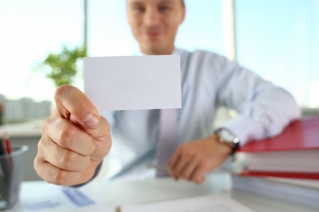 Male arm in suit give blank calling cardの写真素材